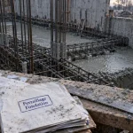 Ferraillage fondation : armatures métalliques sur cales dans une tranchée